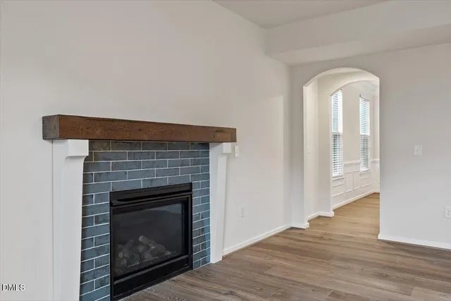a view of empty room with wooden floor and fireplace