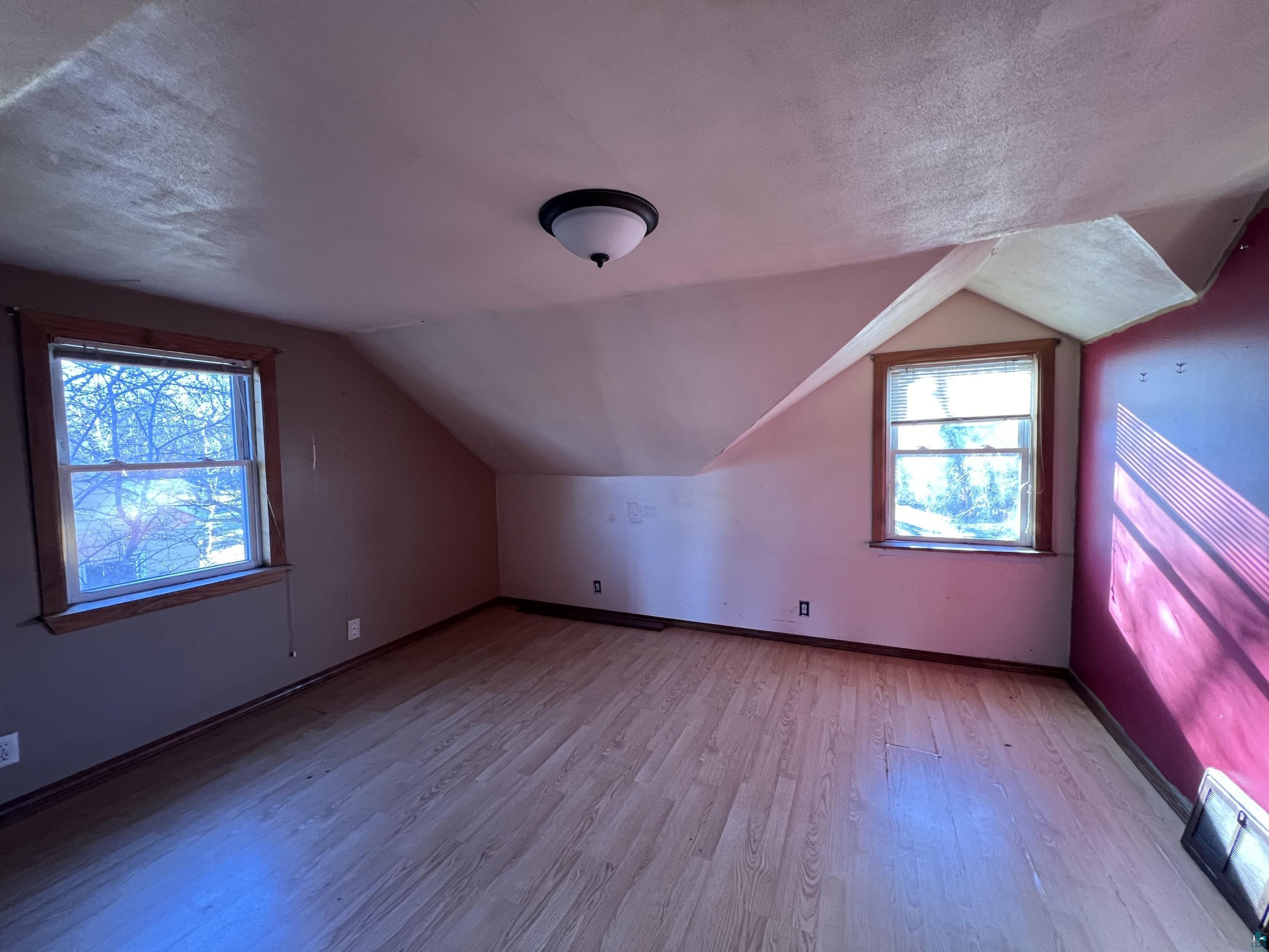 4207 East 3rd Street Superior, WI 54880 - Photo 12 of 23 Additional living space featuring light hardwood / wood-style floors, lofted ceiling, and a textured ceiling