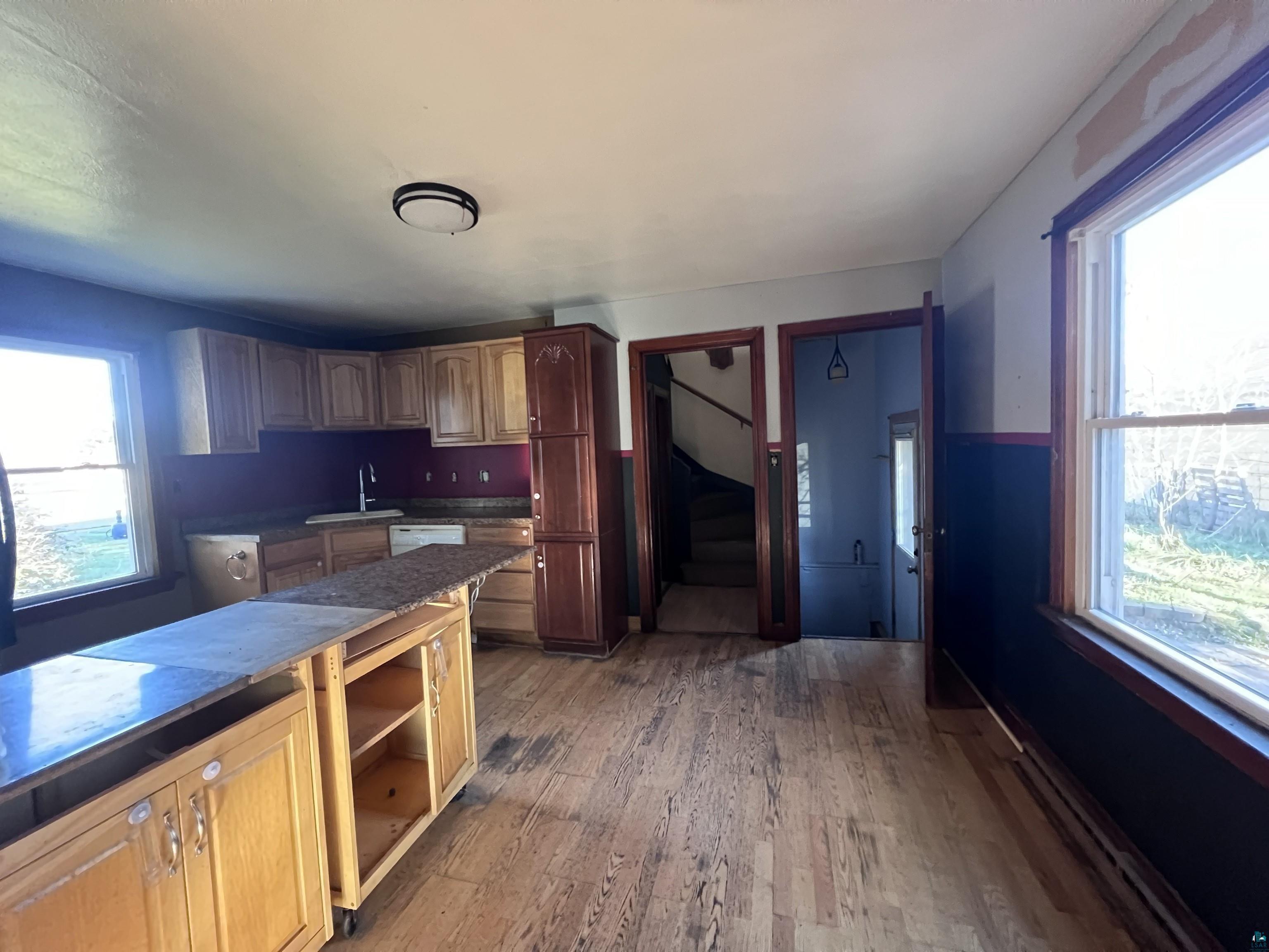4207 East 3rd Street Superior, WI 54880 - Photo 6 of 23 Kitchen featuring dishwasher, sink, a healthy amount of sunlight, and light hardwood / wood-style flooring