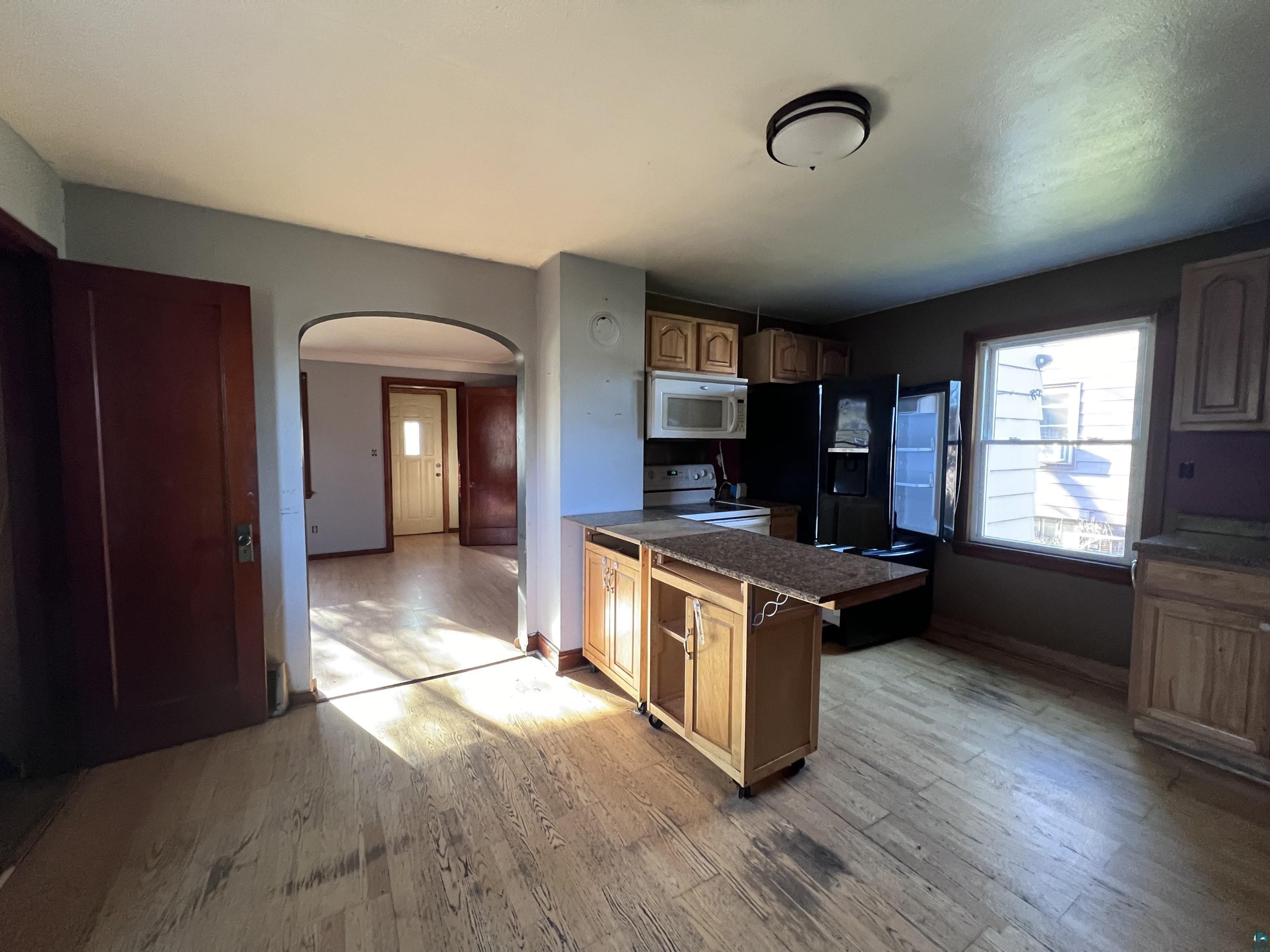 4207 East 3rd Street Superior, WI 54880 - Photo 7 of 23 Kitchen featuring light wood-type flooring and white appliances