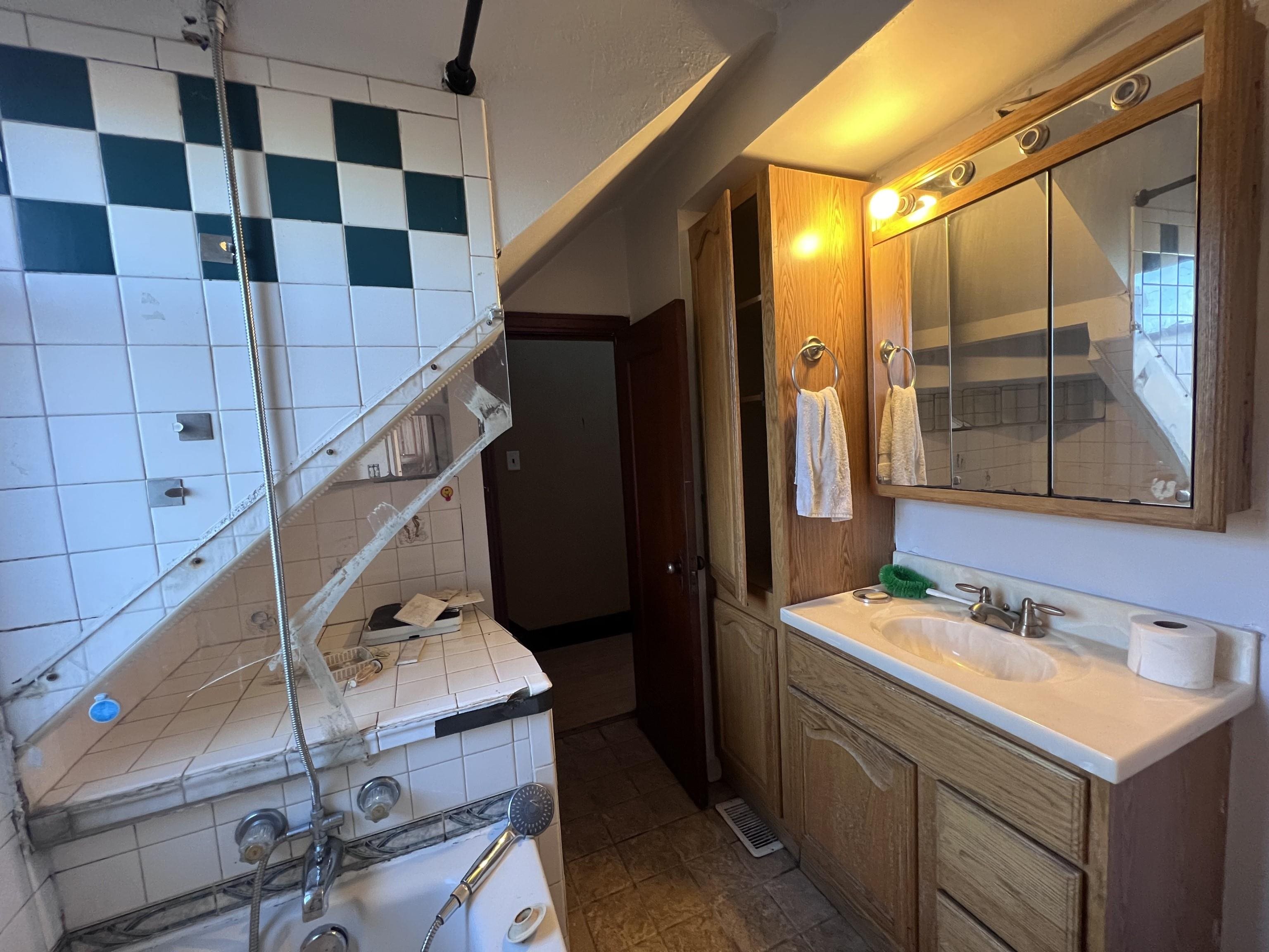 4207 East 3rd Street Superior, WI 54880 - Photo 10 of 23 Bathroom featuring decorative backsplash, tile patterned flooring, and vanity