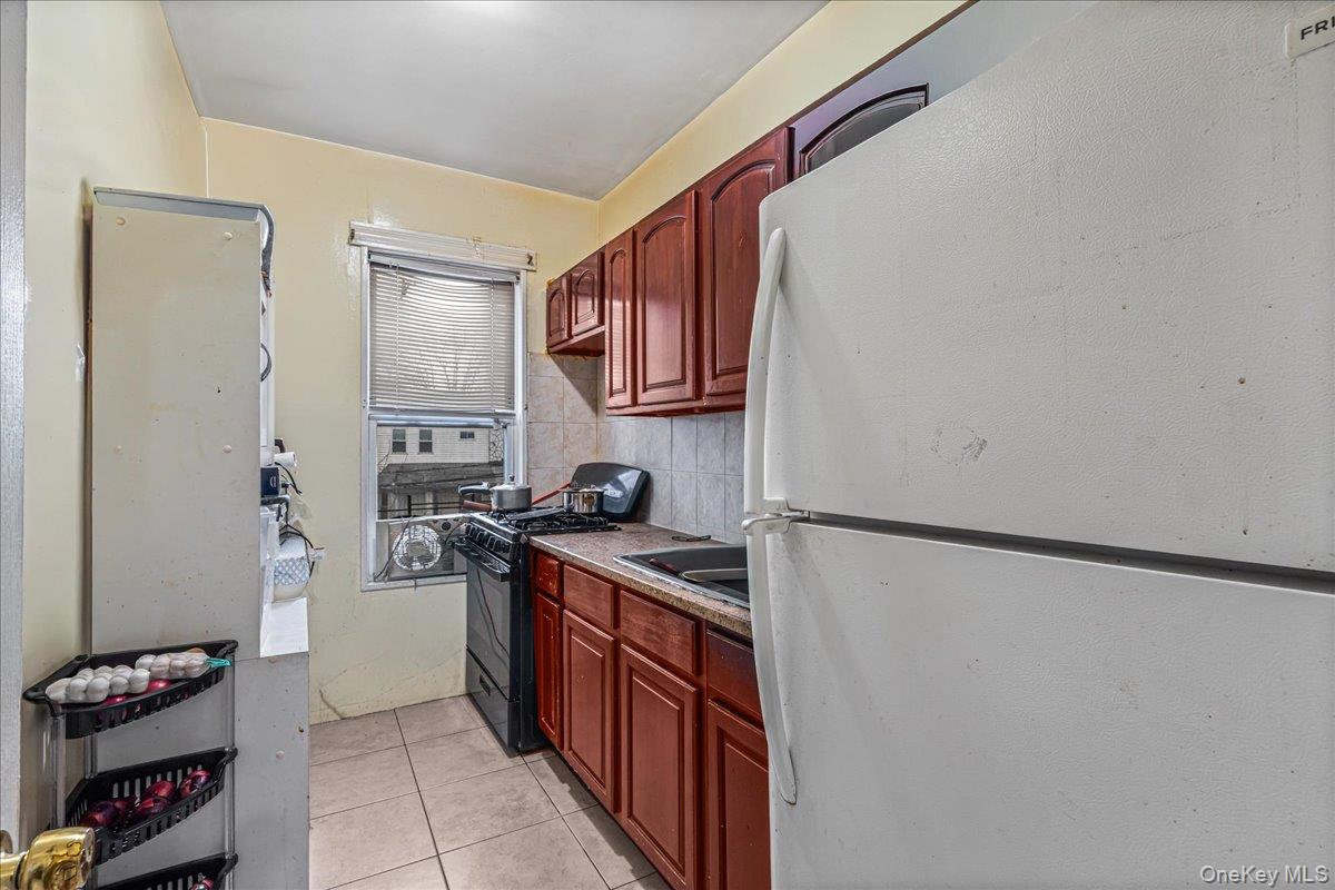 89-21 129th Street Queens, NY 11418 - Photo 16 of 19 a kitchen with stainless steel appliances granite countertop a refrigerator and a sink