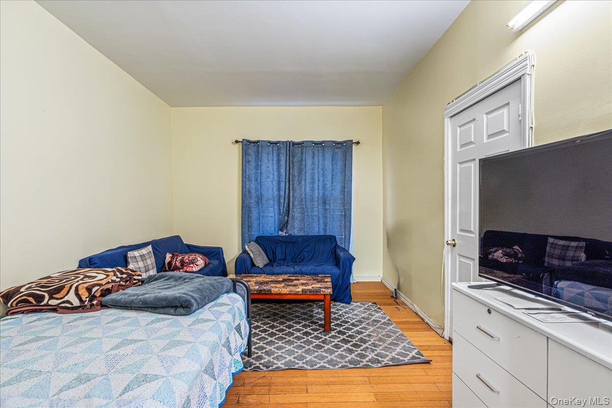 89-21 129th Street Queens, NY 11418 - Photo 7 of 19 a bedroom with a bed and a television