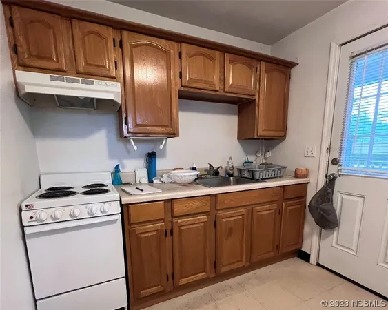 a kitchen with granite countertop wooden cabinets stainless steel appliances and a sink