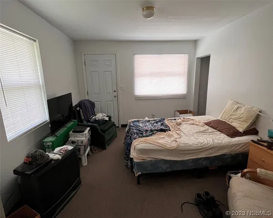 a bedroom with bed couch and window