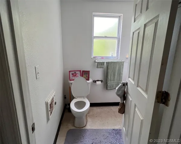 a white toilet sitting next to a sink and a window