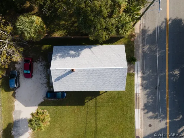 an aerial view of a residential houses with yard