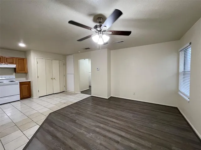 a view of an empty room with window and wooden floor