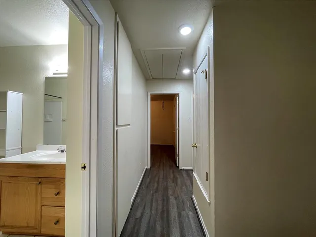 a view of a hallway with wooden floor and closet area