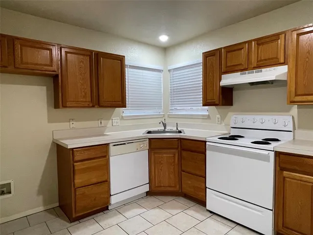 a kitchen with a stove sink and cabinets