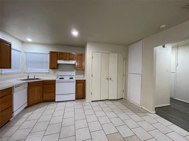 a large kitchen with a stove top oven cabinets a sink and a counter top space