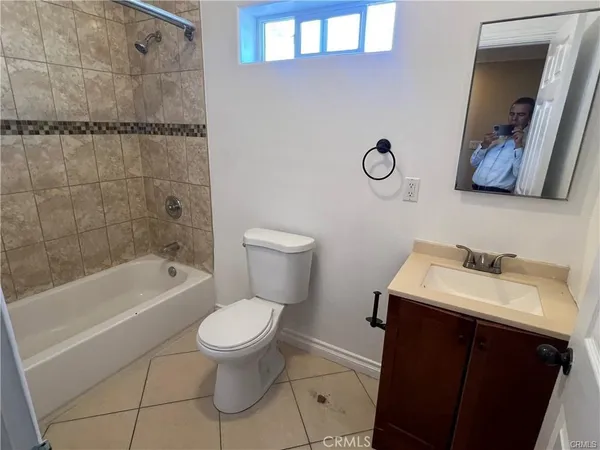 a bathroom with a toilet sink vanity tub and mirror