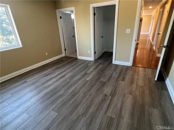 an empty room with wooden floor and a window