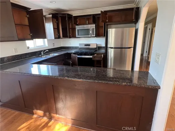 a kitchen with granite countertop a refrigerator and a sink