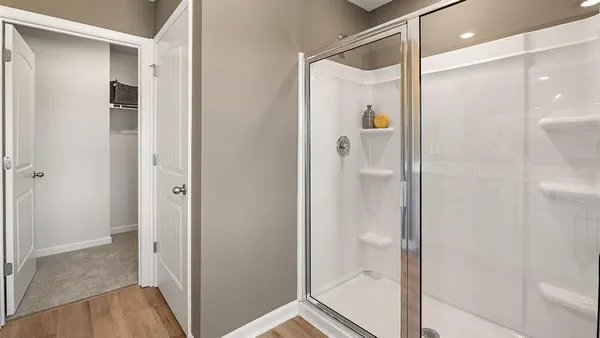 a bathroom with a glass shower door and a glass door