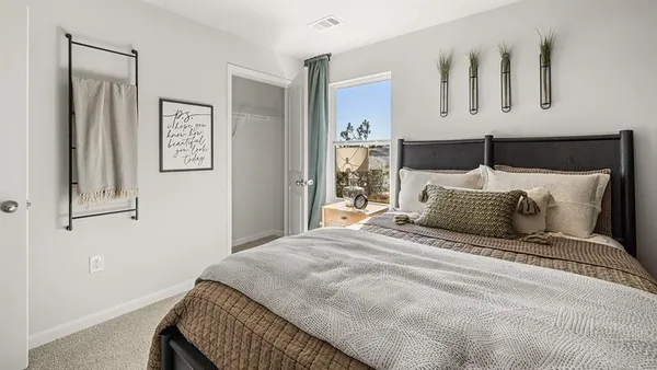 a bedroom with a large bed and paintings on the wall