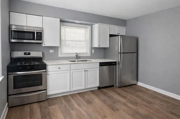 a kitchen with a sink a microwave a refrigerator and cabinets