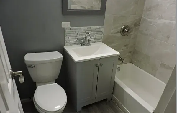 a bathroom with a toilet sink and mirror