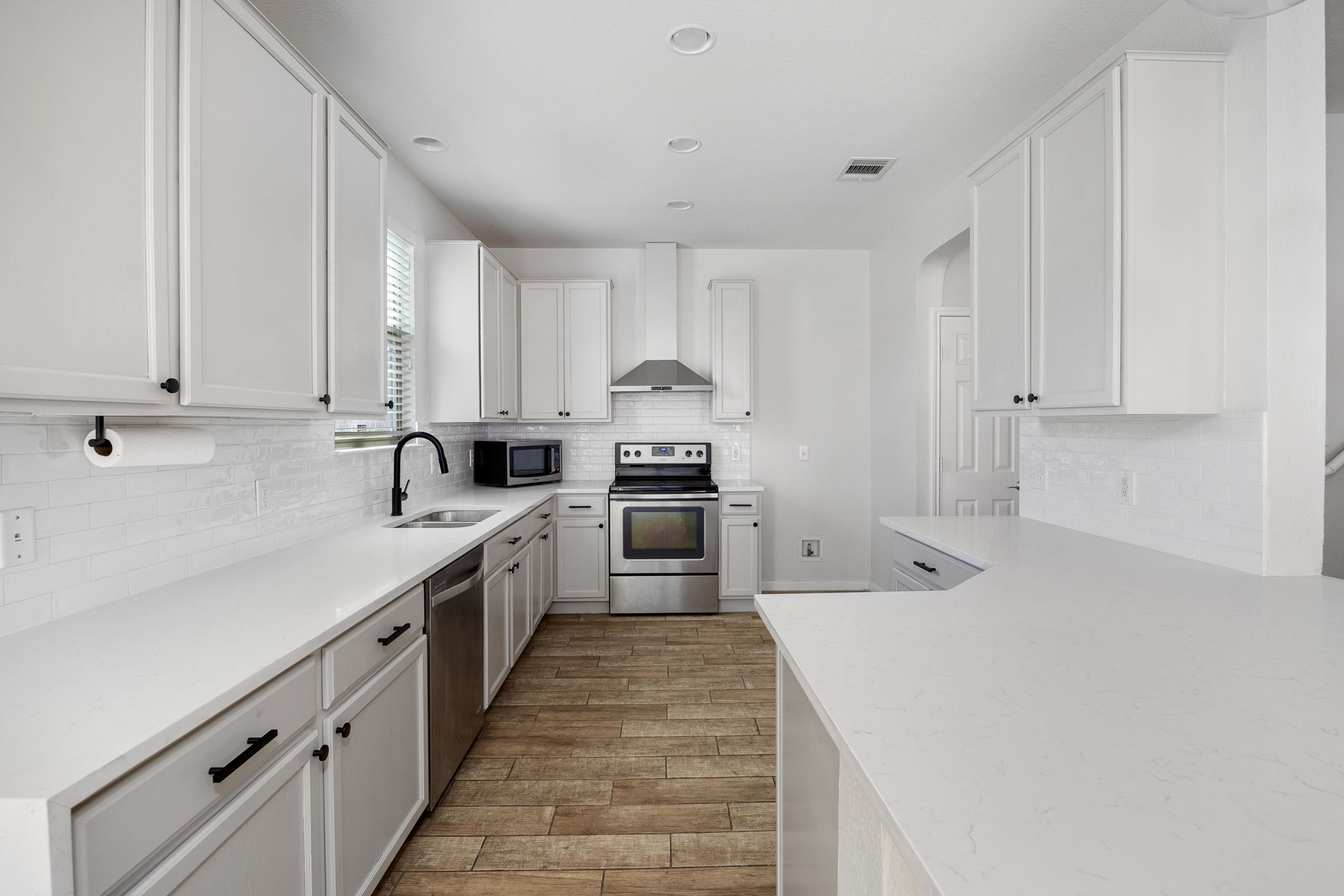 8909 Winter Haven Road Austin, TX 78747 - Photo 15 of 37 a kitchen with granite countertop white cabinets and stainless steel appliances
