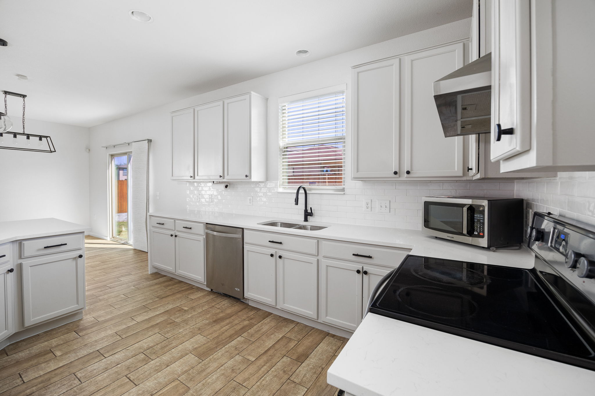 8909 Winter Haven Road Austin, TX 78747 - Photo 16 of 37 a kitchen with granite countertop white cabinets and white appliances