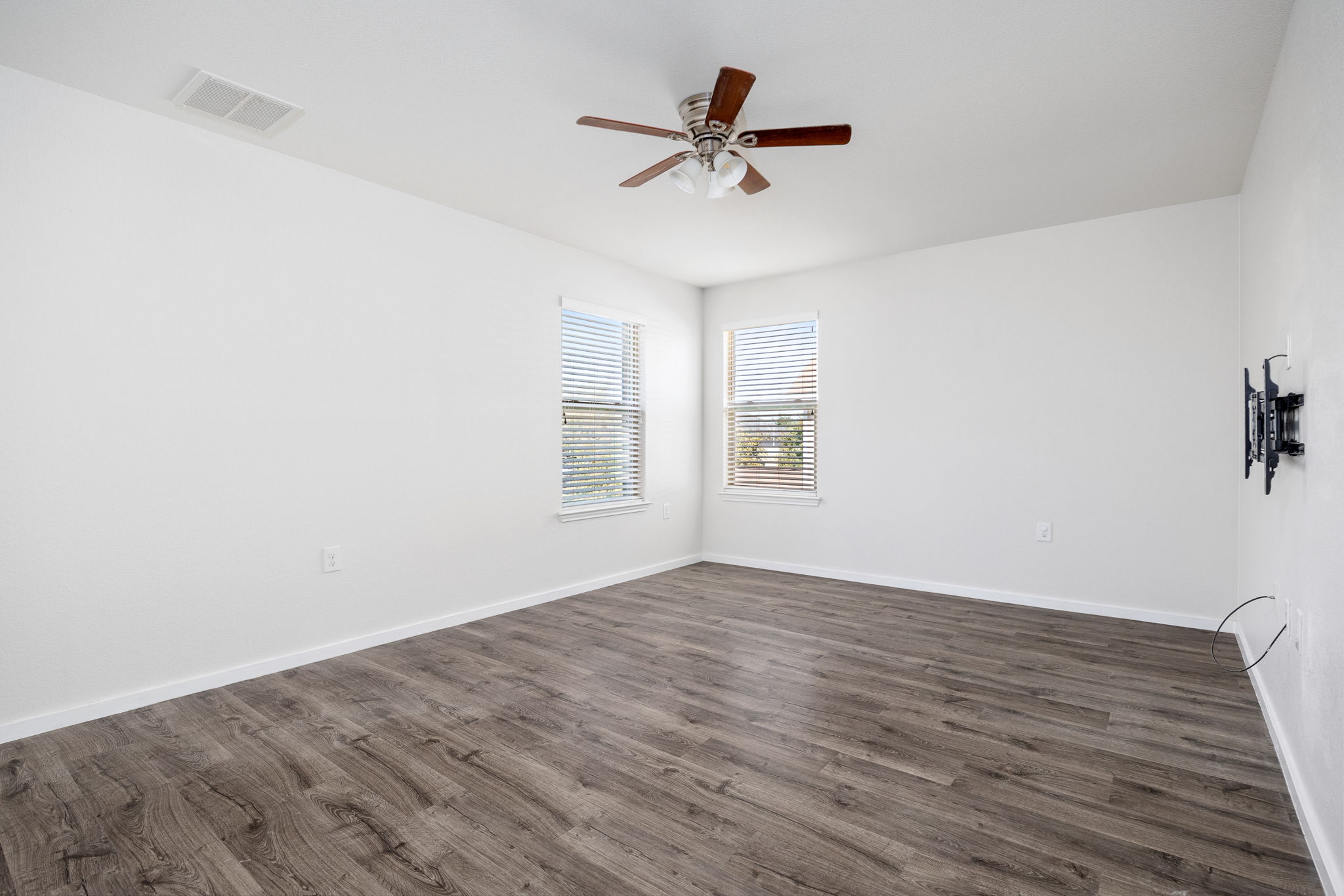 8909 Winter Haven Road Austin, TX 78747 - Photo 24 of 37 an empty room with wooden floor fan and windows