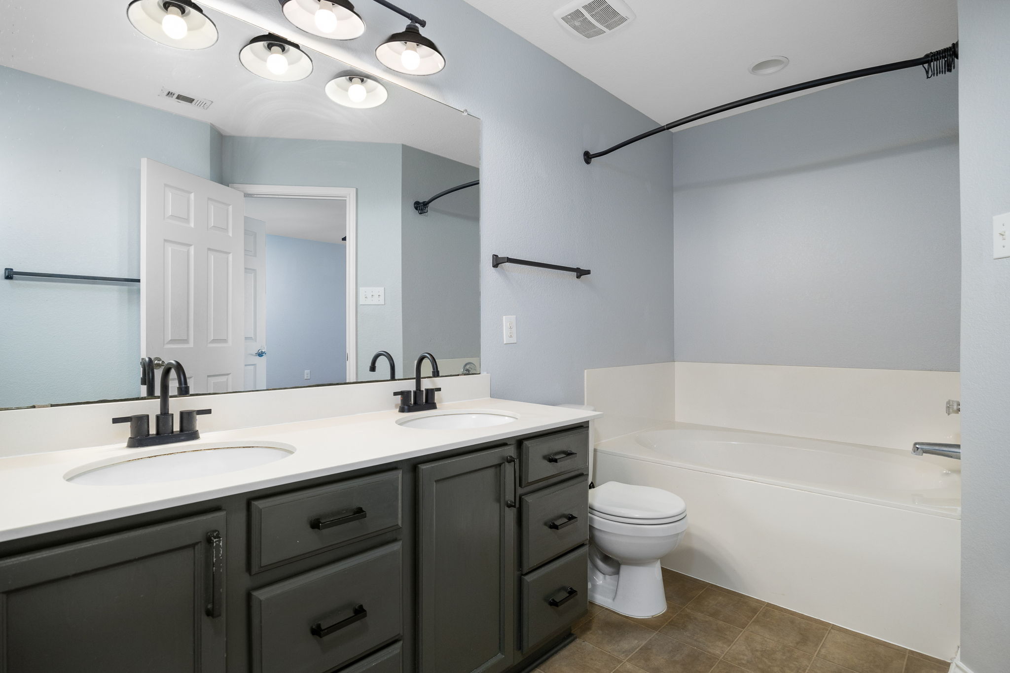 8909 Winter Haven Road Austin, TX 78747 - Photo 30 of 37 a bathroom with a toilet a sink a mirror and a bathtub