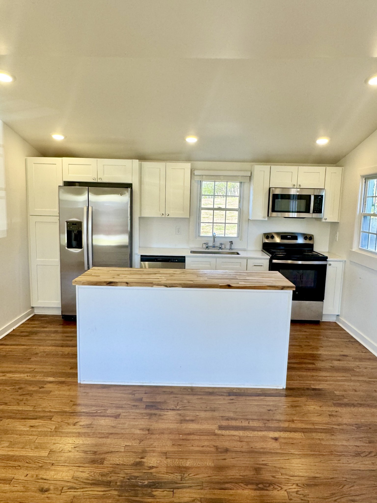 8649 Taliaferro Road Eagleville, TN 37060 - Photo 19 of 24 a large kitchen with kitchen island a sink wooden floor and stainless steel appliances