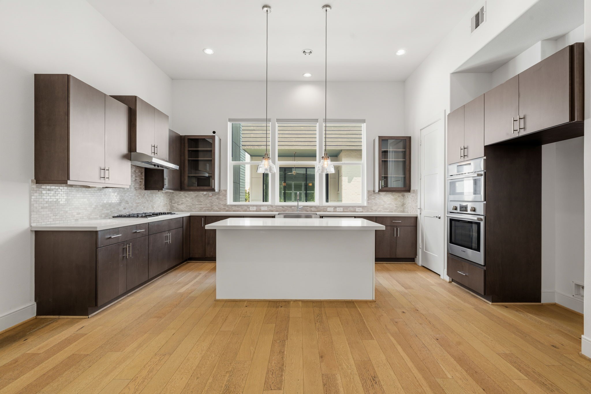 2624 Rusk Street Houston, TX 77003 - Photo 14 of 30 Spacious kitchen featuring sleek dark cabinetry, a central island, and modern stainless steel appliances, perfect for culinary enthusiasts.