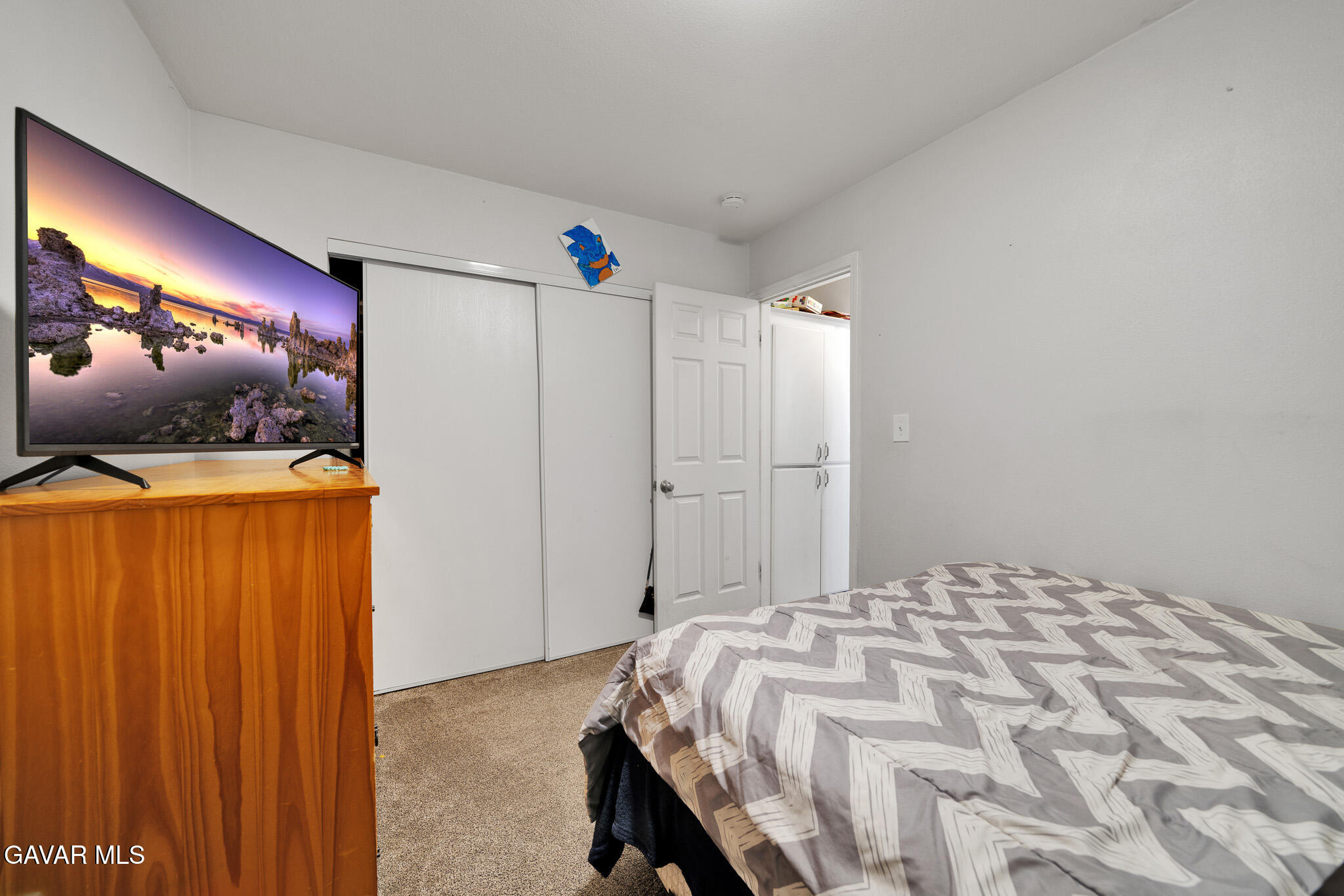 44188 Glenraven Road Lancaster, CA 93535 - Photo 19 of 26 a bedroom with a bed and a flat screen tv