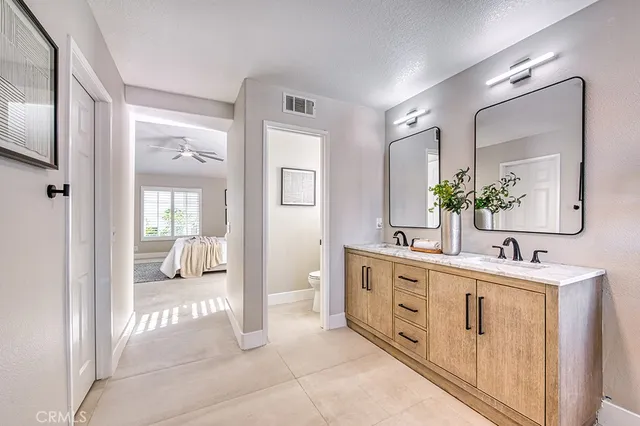 a spacious en suite bathroom with a double vanity sink a mirror and shower