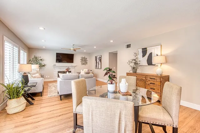 a living room with lots of white furniture and wooden floor