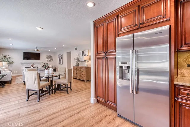 a kitchen with stainless steel appliances granite countertop a refrigerator a stove and a wooden floors
