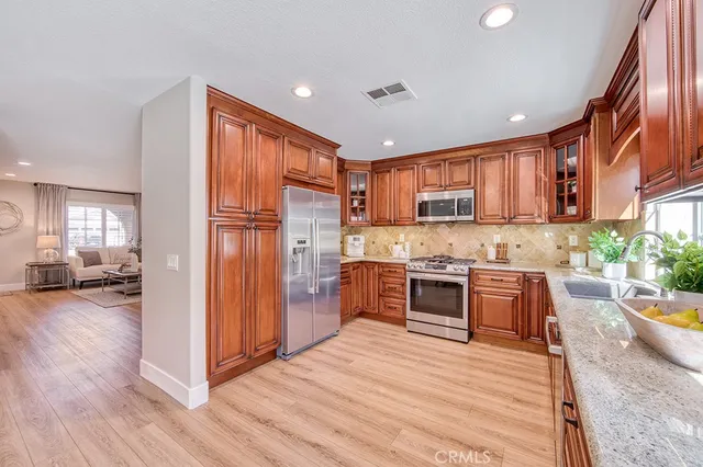 a kitchen with stainless steel appliances granite countertop a refrigerator stove top oven and sink