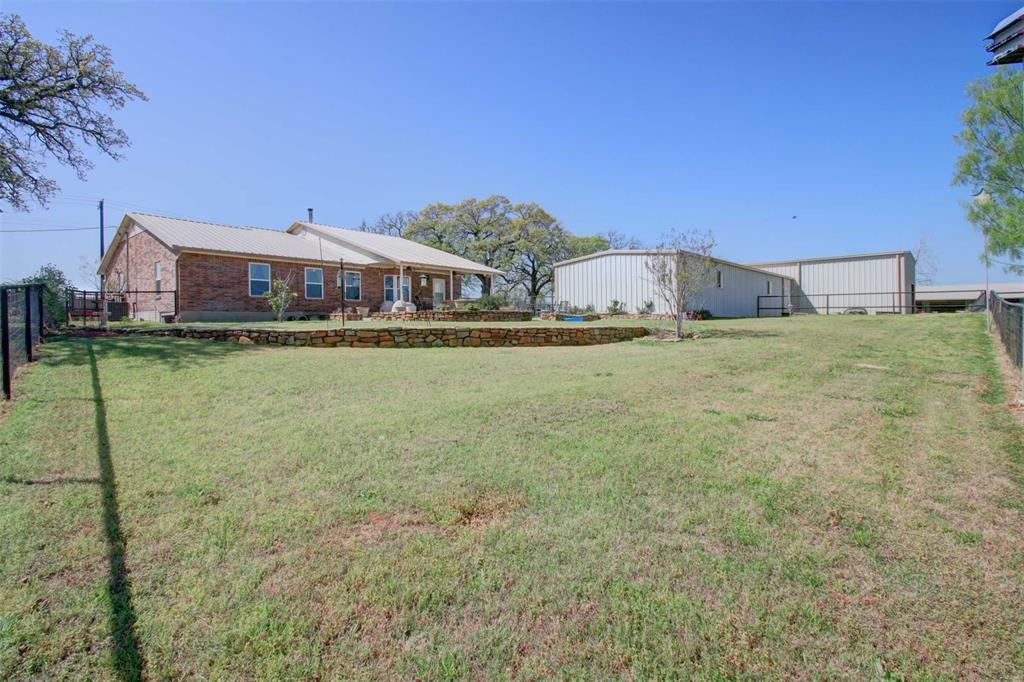 3559 Springfield Road Springtown, TX 76082 - Photo 34 of 37 a view of a house with a yard and potted plants