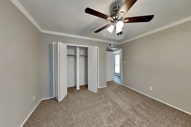 a view of an empty room and chandelier fan