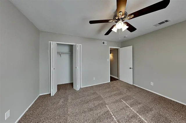 a view of an empty room with a ceiling fan