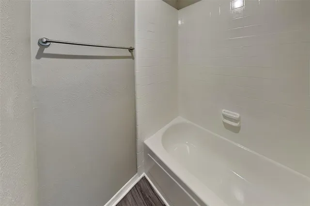 a bathroom with a white bath tub and a shower