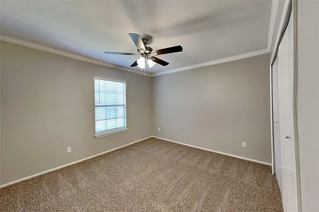 an empty room with windows and ceiling fan