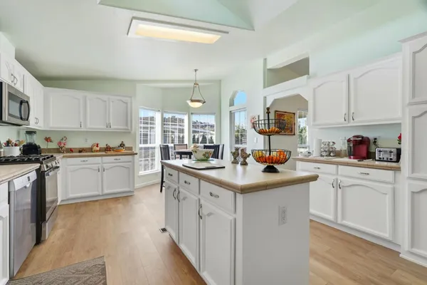 a kitchen with white cabinets and sink