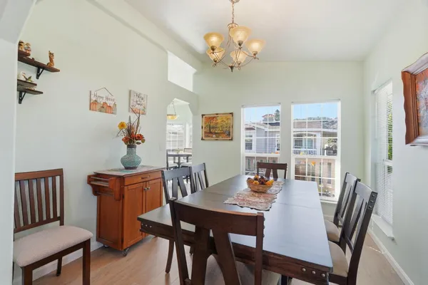 a view of a dining room with furniture a chandelier and wooden floor