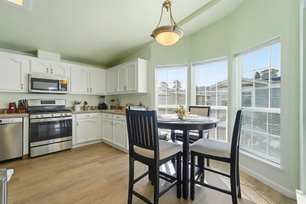 a kitchen with a table chairs microwave and cabinets