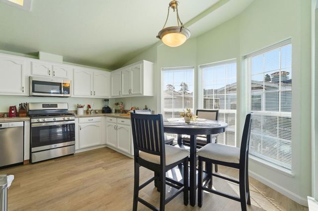 a kitchen with a table chairs microwave and cabinets