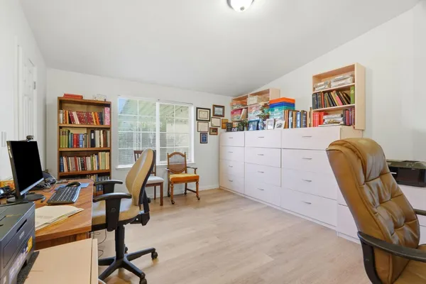 a view of a workspace with furniture and a window