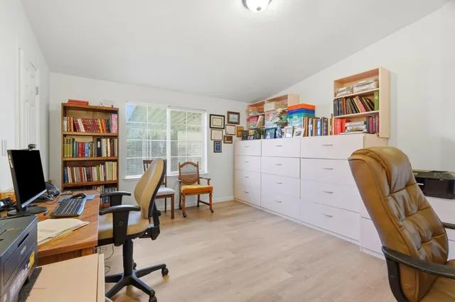 a view of a workspace with furniture and a window