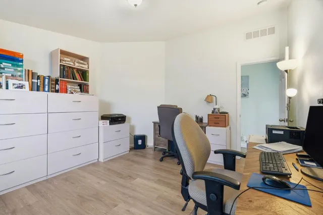 a view of a workspace with furniture and wooden floor