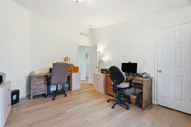 a view of a workspace with furniture and a window