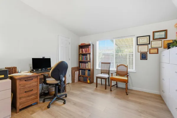 a view of a workspace with furniture and a window