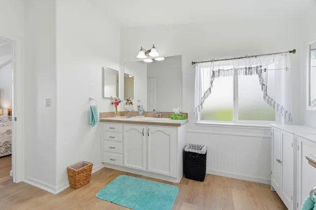 a spacious bathroom with a granite countertop sink and a mirror