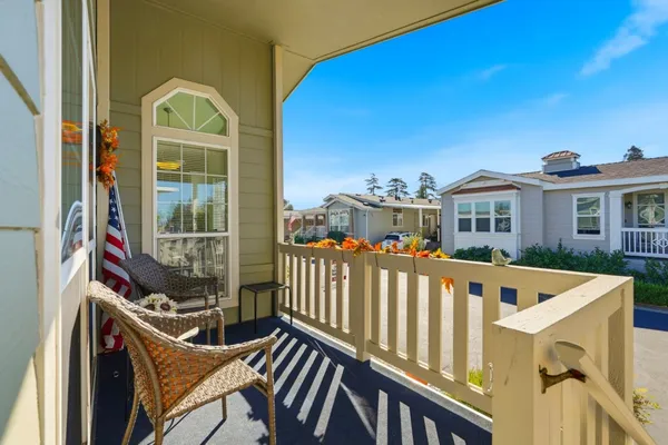 a view of a balcony with a large window and wooden fence