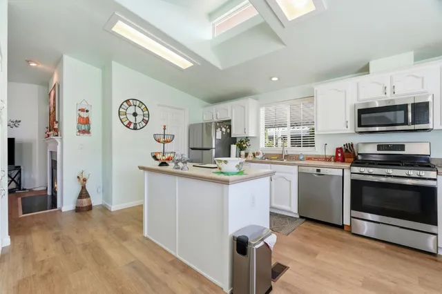 a kitchen with stainless steel appliances granite countertop a refrigerator and a stove top oven